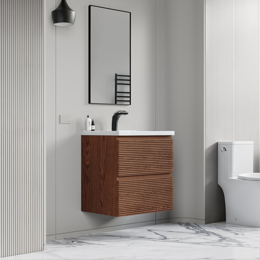 Bathroom vanity with wooden finish and white countertop against a gray wall.