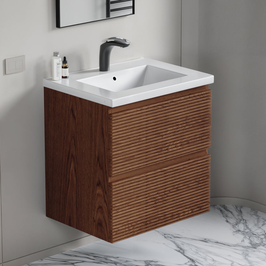 Bathroom vanity with wooden finish and white countertop against a gray wall.