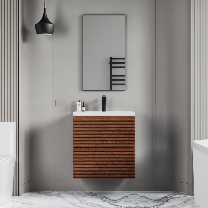 Bathroom vanity with wooden finish and white countertop against a gray wall.