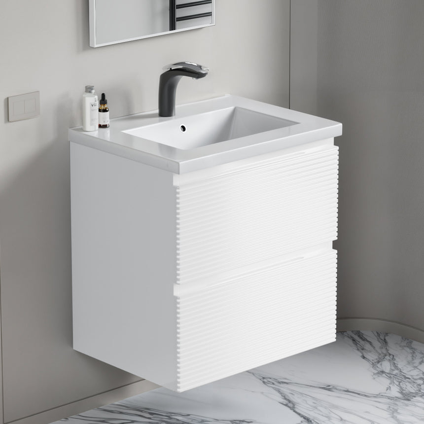 Bathroom vanity with wooden finish and white countertop against a gray wall.