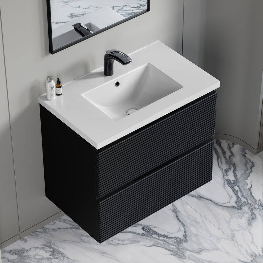 Bathroom vanity with wooden finish and white countertop against a gray wall.