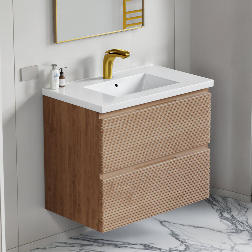 Bathroom vanity with wooden finish and white countertop against a gray wall.