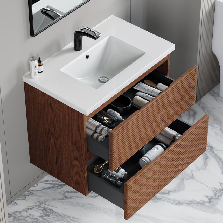 Bathroom vanity with wooden finish and white countertop against a gray wall.