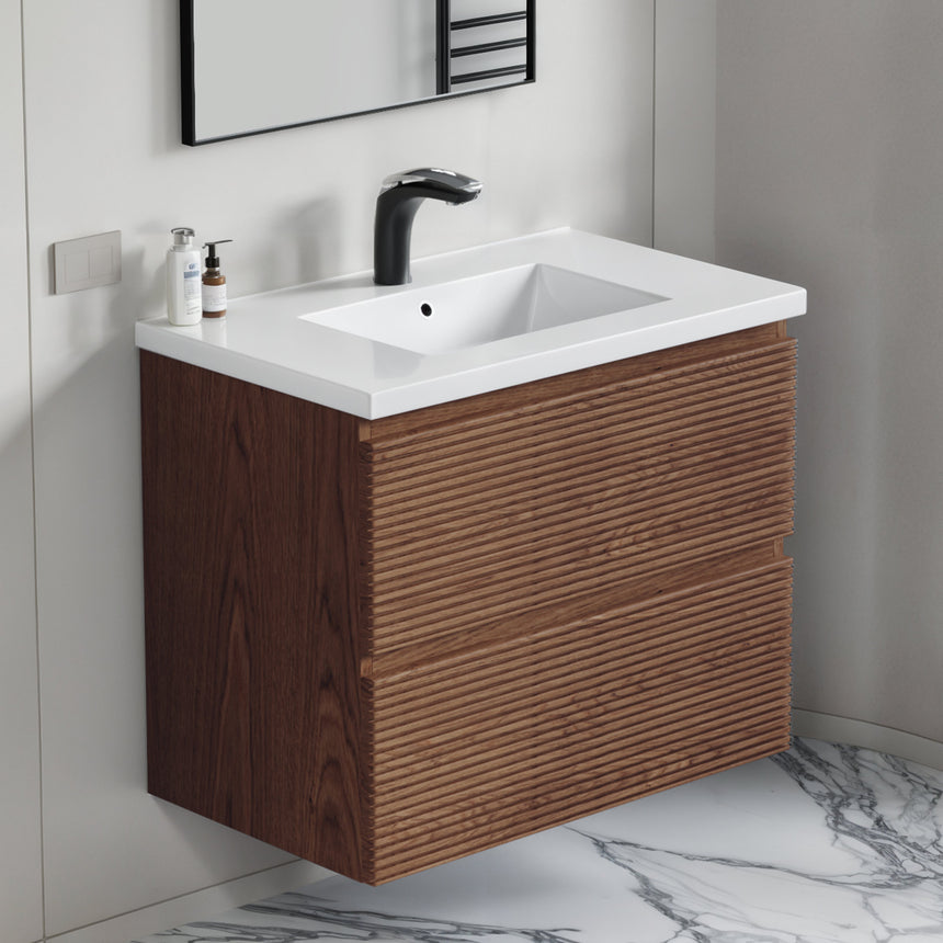 Bathroom vanity with wooden finish and white countertop against a gray wall.