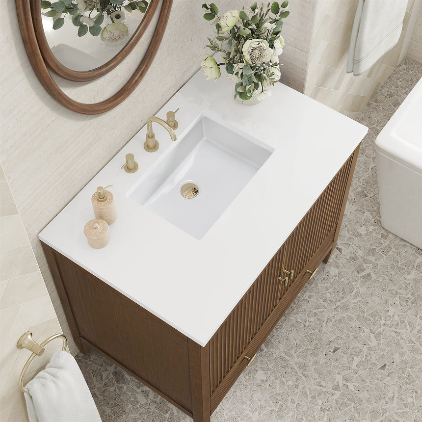 White bathroom vanity with marble countertop and decorative flowers in a bathroom setting.
