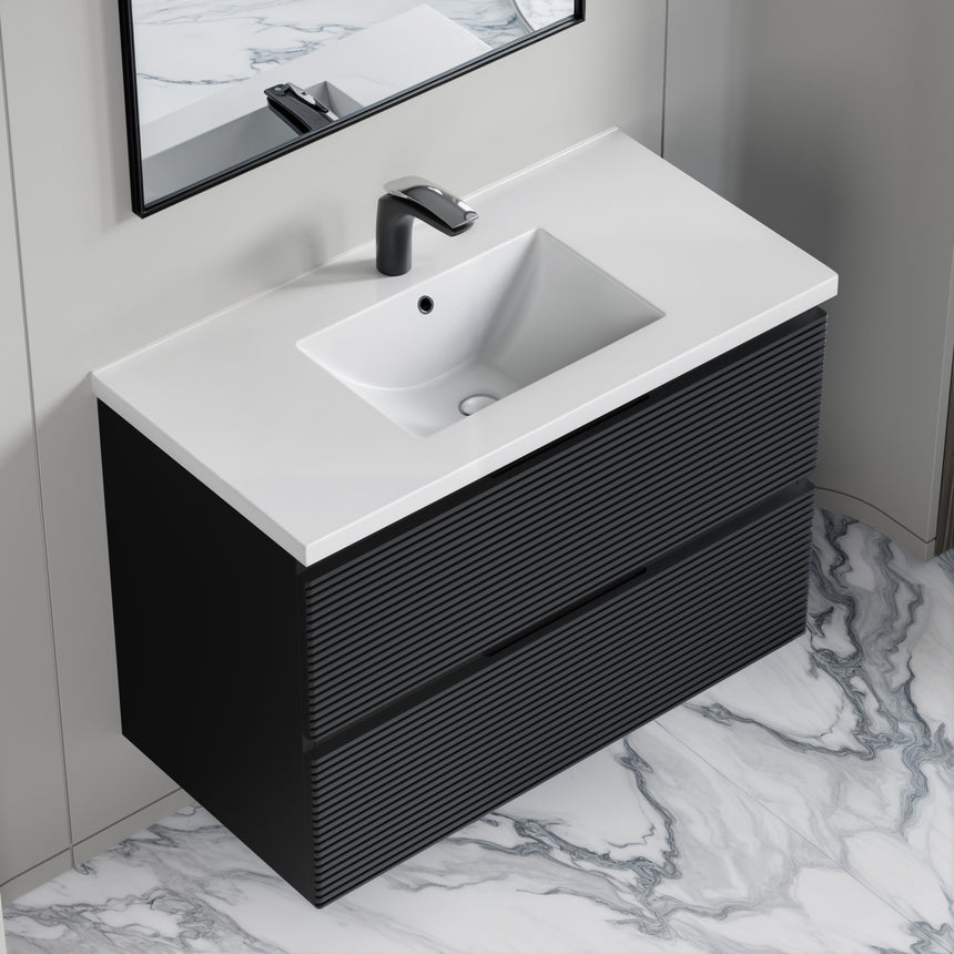 Bathroom vanity with wooden finish and white countertop against a gray wall.