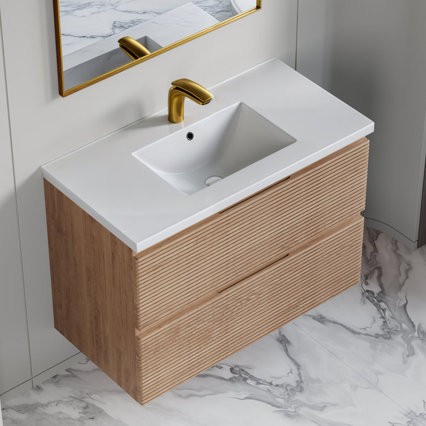 Bathroom vanity with wooden finish and white countertop against a gray wall.