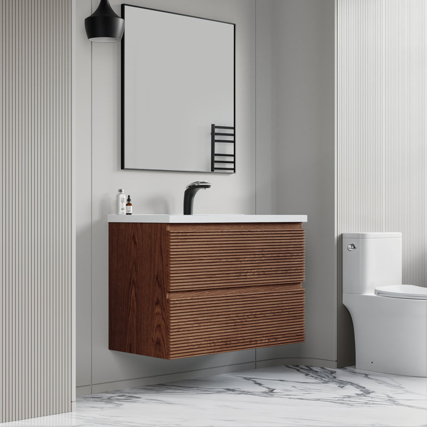 Bathroom vanity with wooden finish and white countertop against a gray wall.