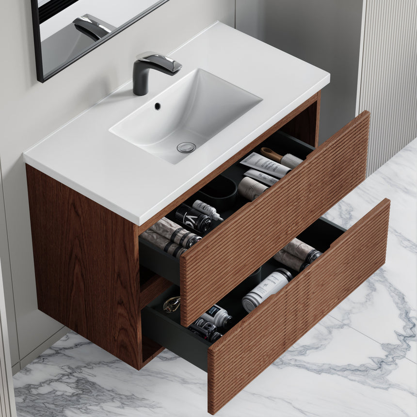 Bathroom vanity with wooden finish and white countertop against a gray wall.