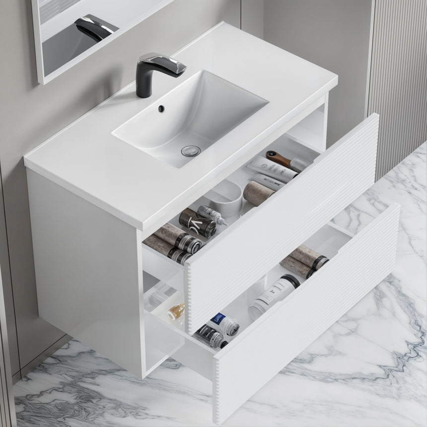 Bathroom vanity with wooden finish and white countertop against a gray wall.