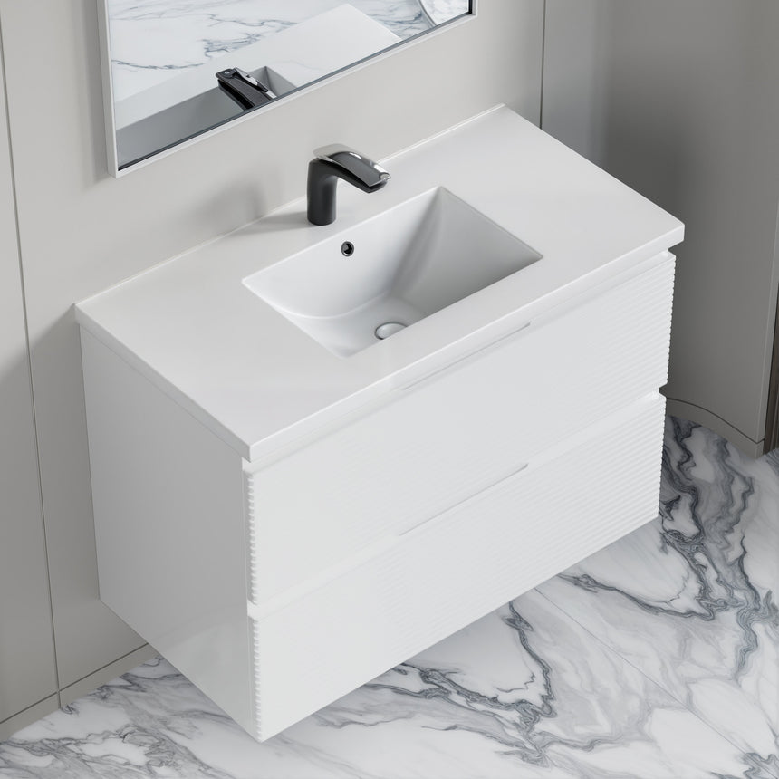 Bathroom vanity with wooden finish and white countertop against a gray wall.