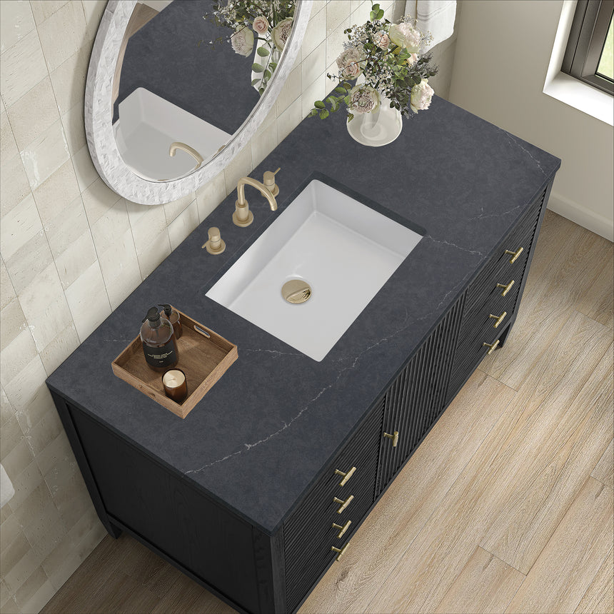 White bathroom vanity with marble countertop and decorative flowers in a bathroom setting.