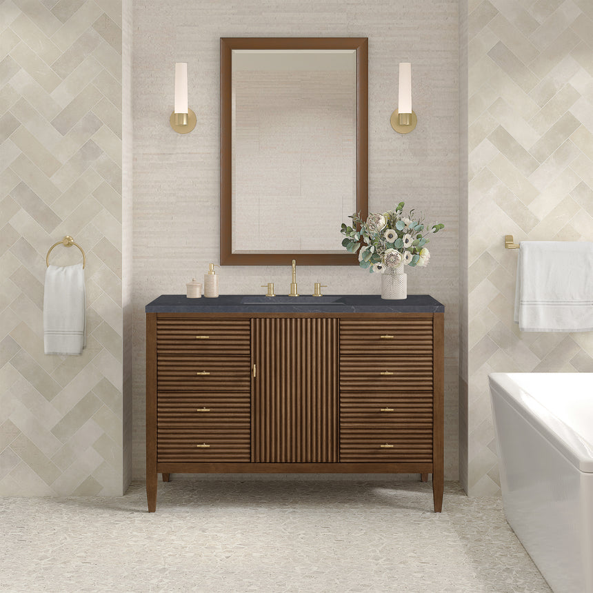 White bathroom vanity with marble countertop and decorative flowers in a bathroom setting.