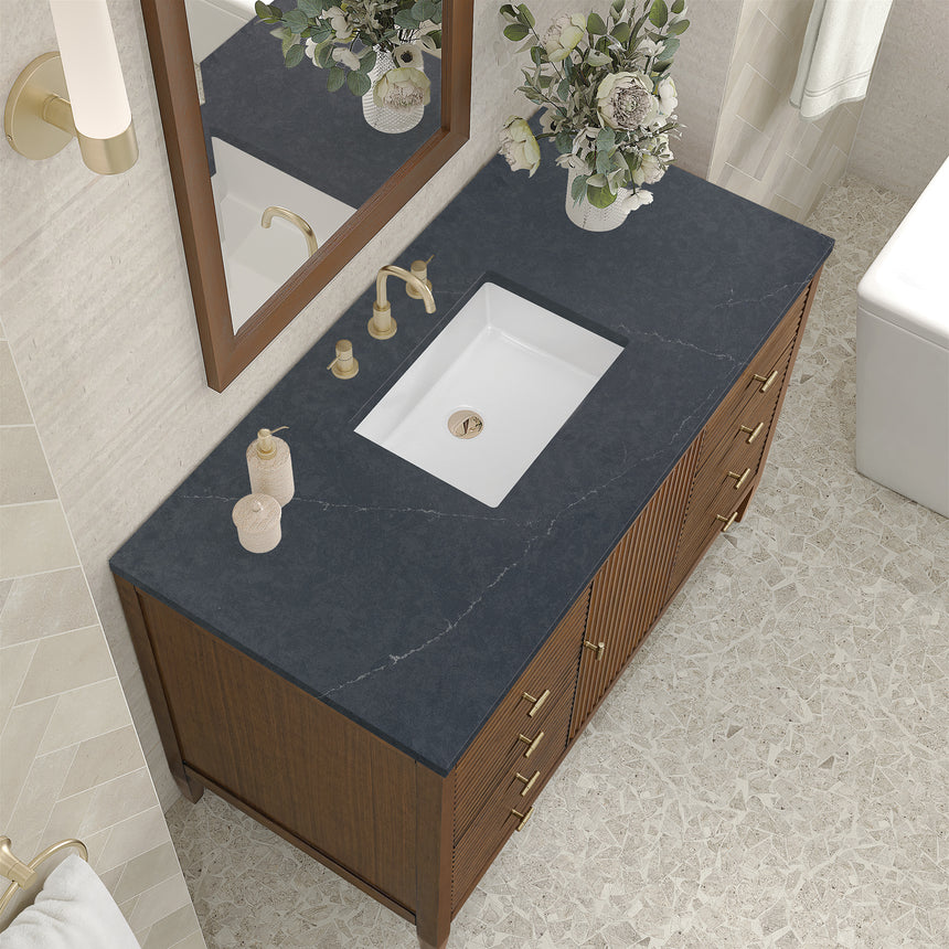White bathroom vanity with marble countertop and decorative flowers in a bathroom setting.