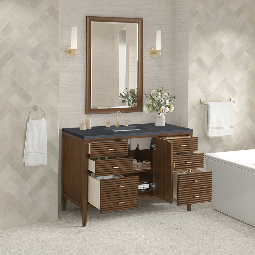 White bathroom vanity with marble countertop and decorative flowers in a bathroom setting.