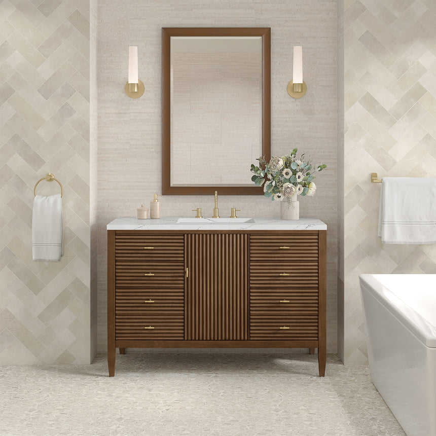 White bathroom vanity with marble countertop and decorative flowers in a bathroom setting.