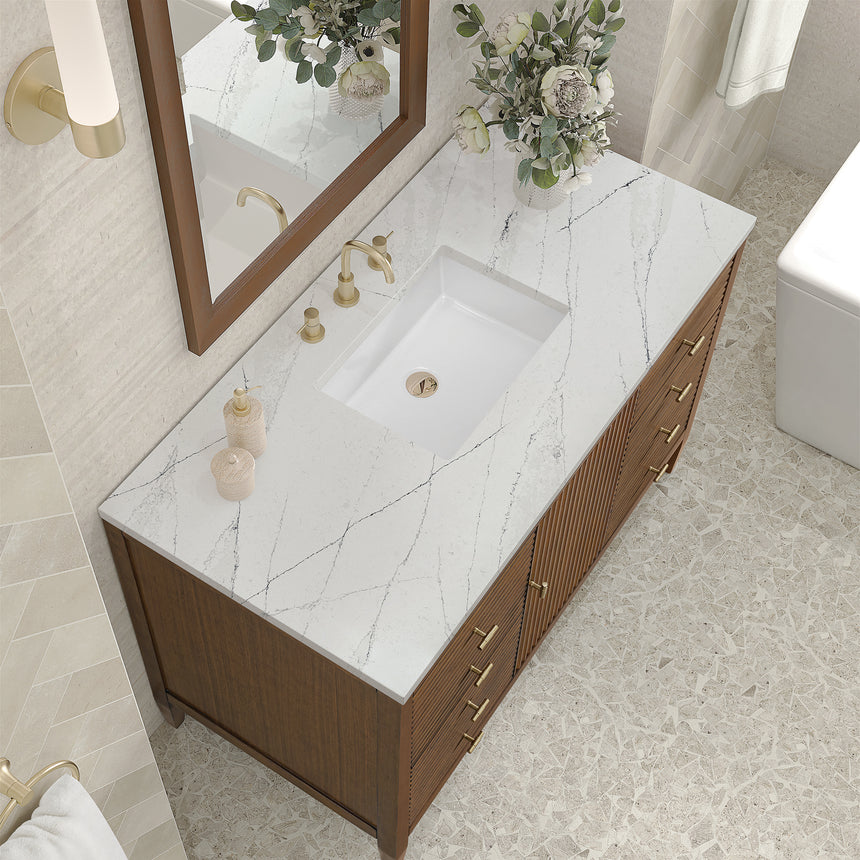 White bathroom vanity with marble countertop and decorative flowers in a bathroom setting.