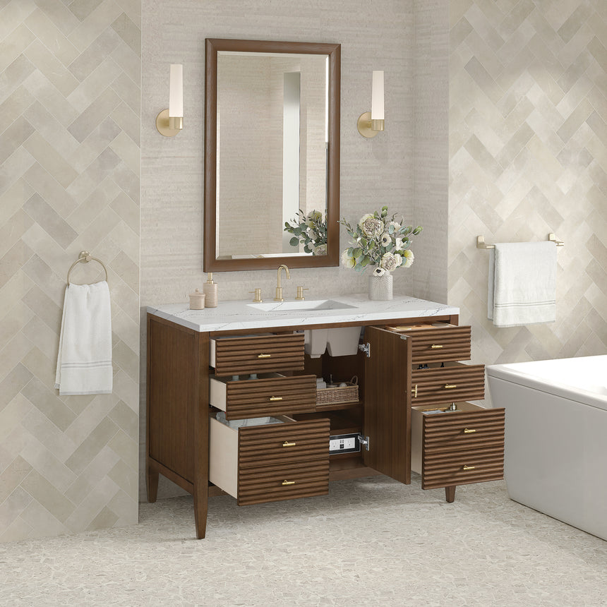 White bathroom vanity with marble countertop and decorative flowers in a bathroom setting.