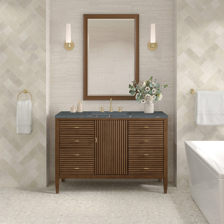 White bathroom vanity with marble countertop and decorative flowers in a bathroom setting.