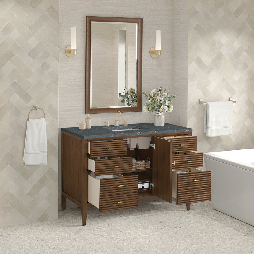 White bathroom vanity with marble countertop and decorative flowers in a bathroom setting.