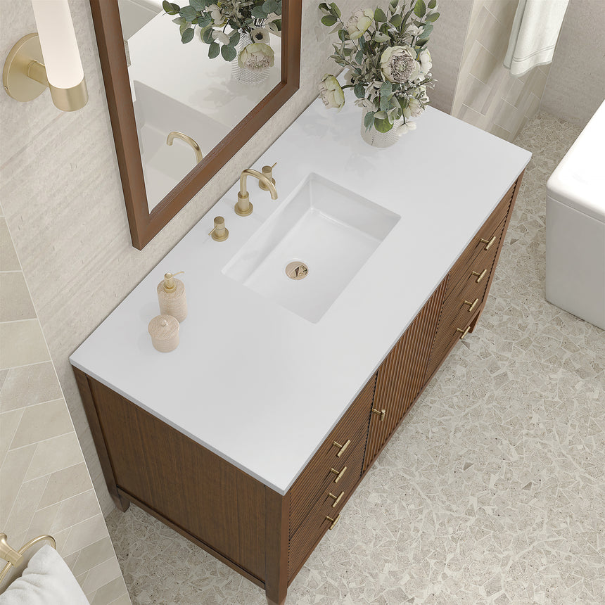 White bathroom vanity with marble countertop and decorative flowers in a bathroom setting.
