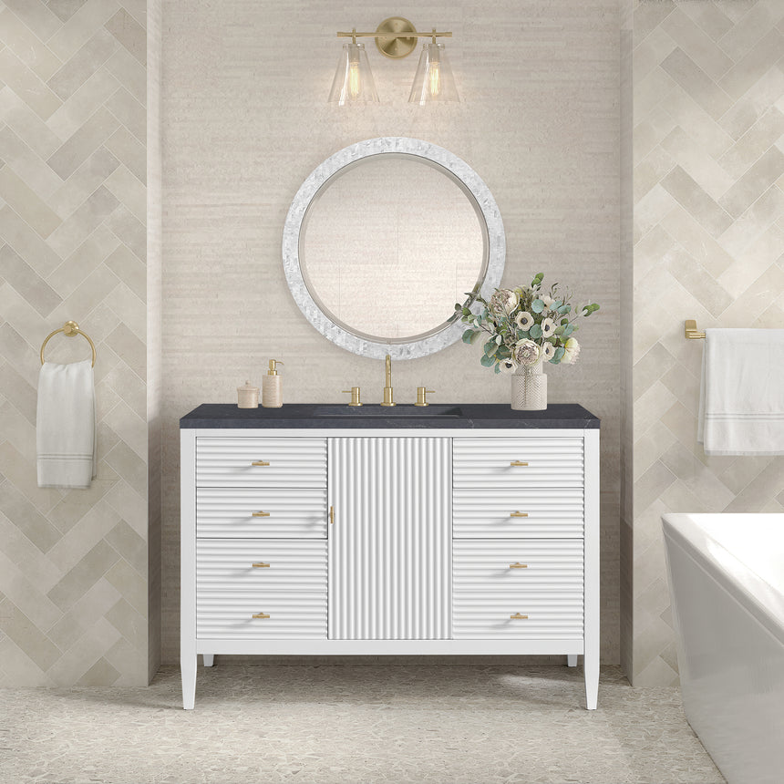 White bathroom vanity with marble countertop and decorative flowers in a bathroom setting.