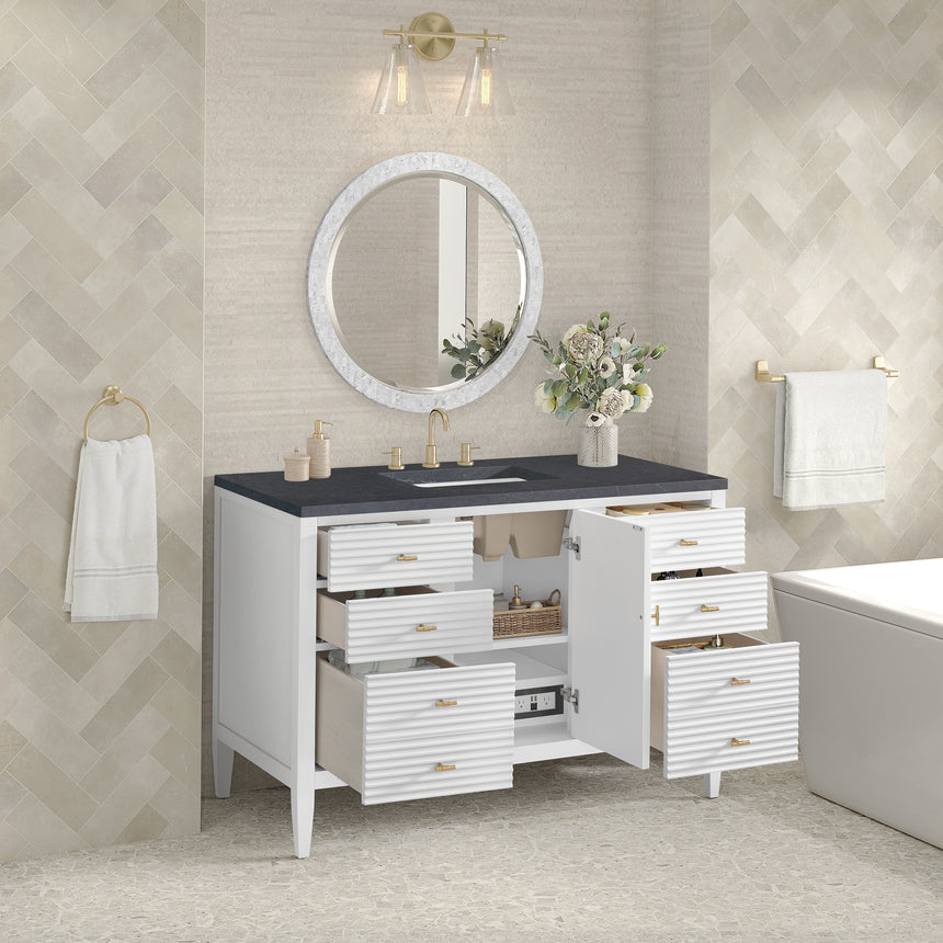 White bathroom vanity with marble countertop and decorative flowers in a bathroom setting.