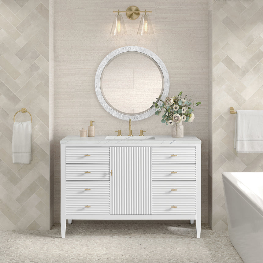 White bathroom vanity with marble countertop and decorative flowers in a bathroom setting.