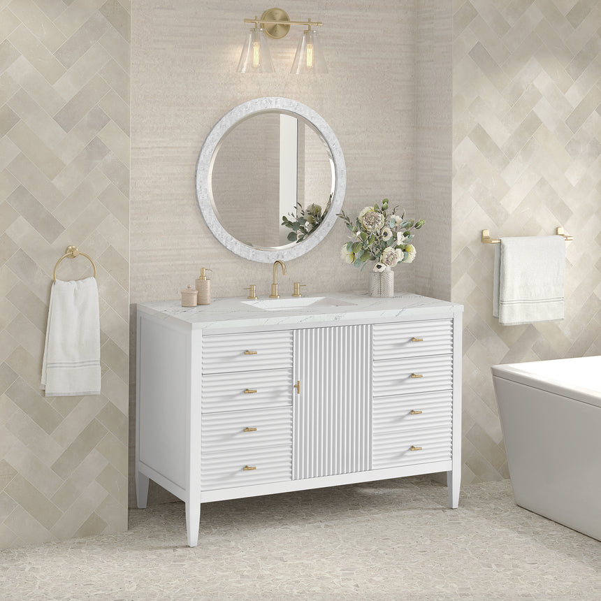 White bathroom vanity with marble countertop and decorative flowers in a bathroom setting.