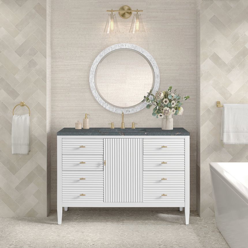 White bathroom vanity with marble countertop and decorative flowers in a bathroom setting.