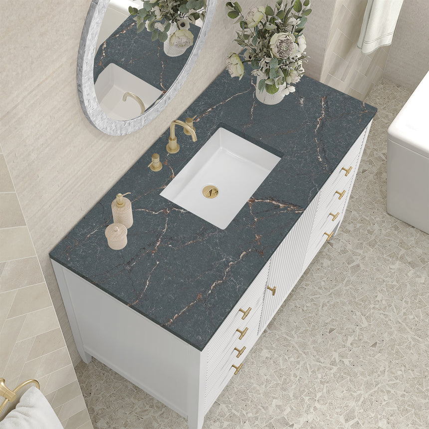 White bathroom vanity with marble countertop and decorative flowers in a bathroom setting.