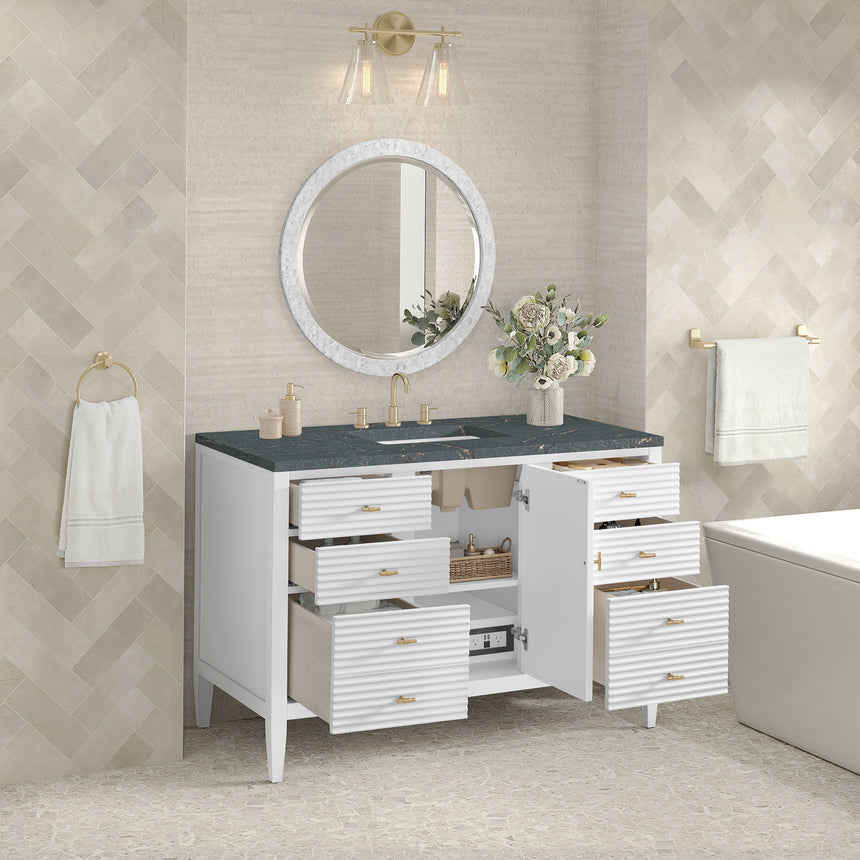 White bathroom vanity with marble countertop and decorative flowers in a bathroom setting.