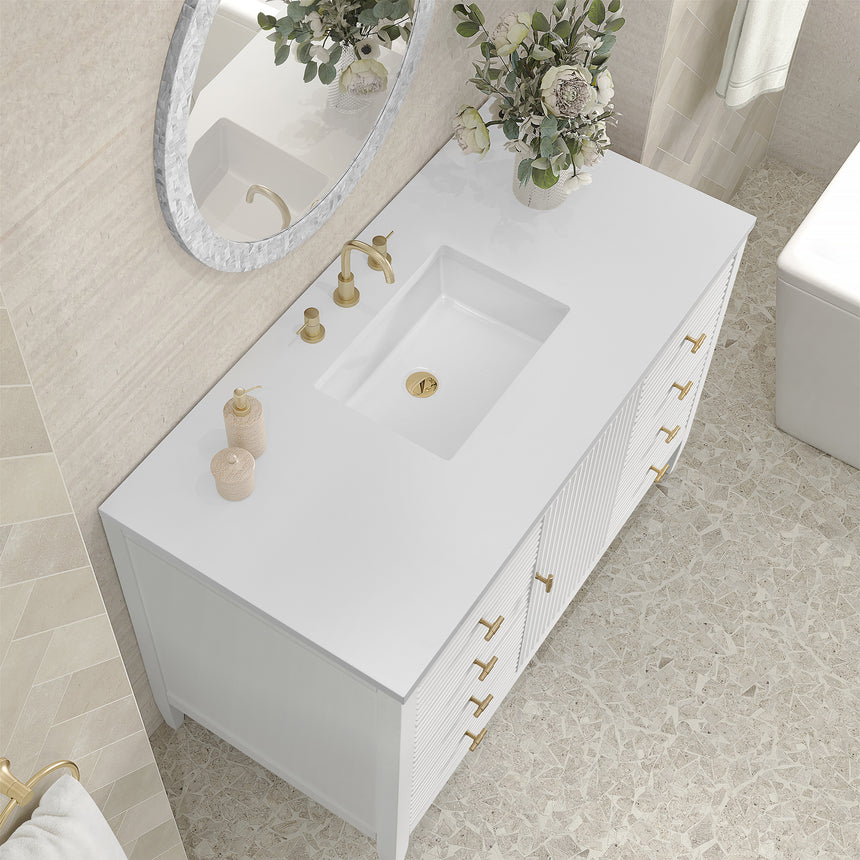 White bathroom vanity with marble countertop and decorative flowers in a bathroom setting.