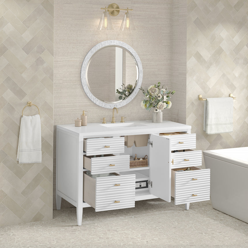 White bathroom vanity with marble countertop and decorative flowers in a bathroom setting.