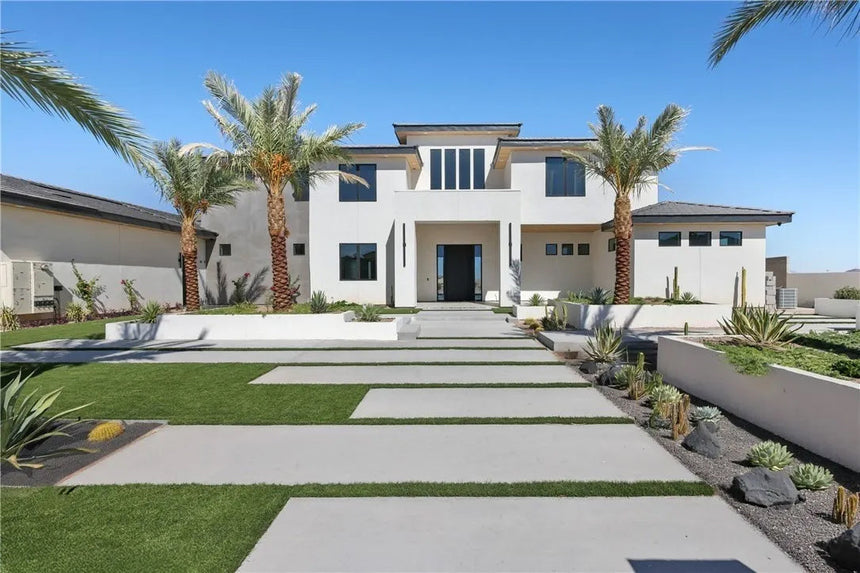 Front exterior of a luxury white Colonial-style estate with grand columns, circular driveway, and manicured lawn in Chino Hills, California.