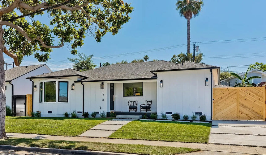 Modern single-story home exterior in Los Angeles CA 90019 with white siding, black trim, and natural wood gate.