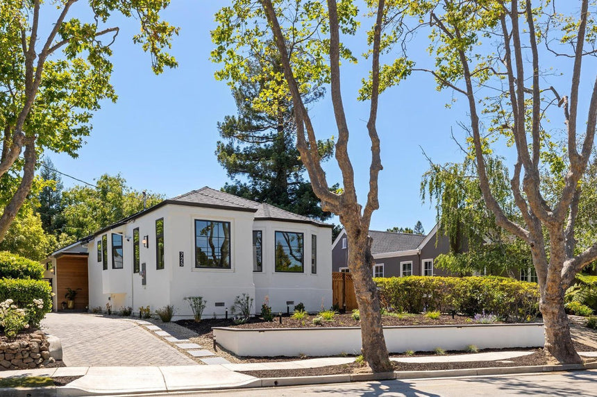 Modern single-story home in Berkeley CA with white stucco exterior, black-framed windows, and landscaped front yard.