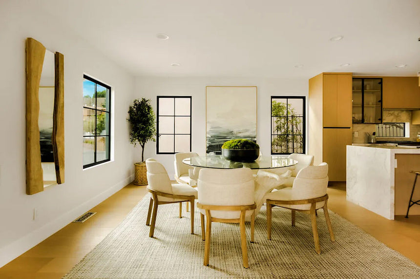 Modern dining room in Los Angeles featuring natural wood tones, round glass table, and minimalist decor.
