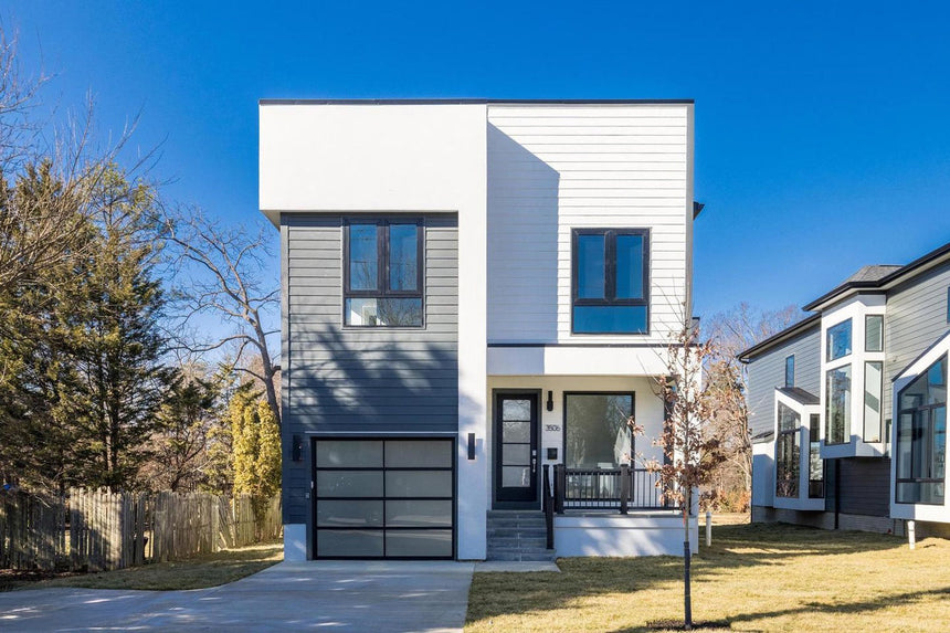 Contemporary two-story home exterior with black trim and modern garage design