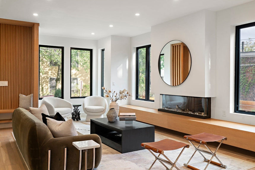 Modern mid-century home exterior with large glass garage doors, sloped roofline, and landscaped front yard at sunset.