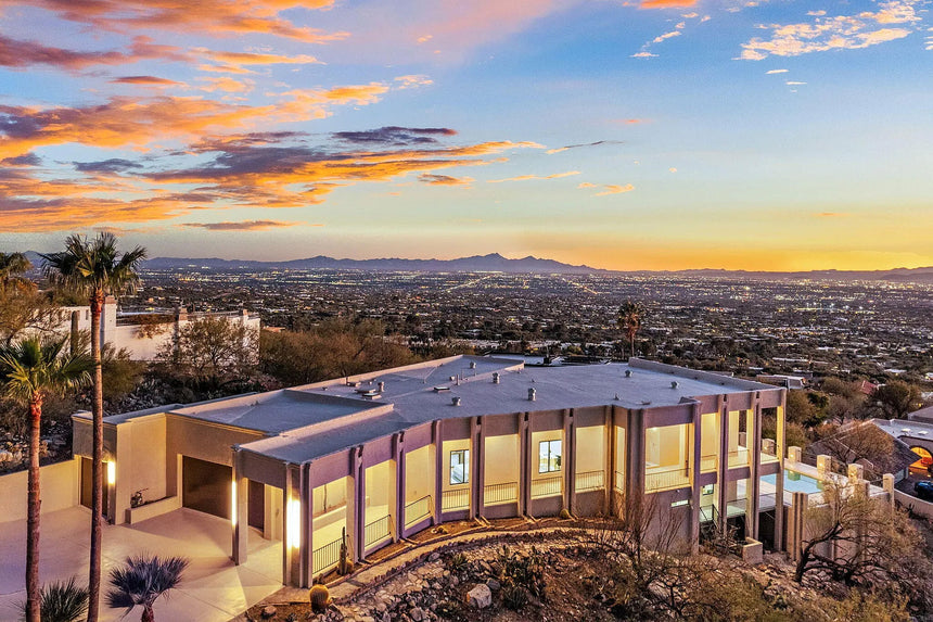 Modern luxury home exterior at sunset in Tucson Arizona with city and mountain views