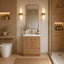 Modern bathroom with wooden vanity, mirror, and toilet.