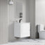 Modern bathroom with a white vanity unit, mirror, and toilet.