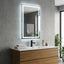 Bathroom vanity with illuminated mirror, sink, and decorative items.