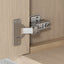 Metallic cabinet hinge on a wooden surface