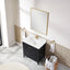 Bathroom with black vanity, white sink, and gold fixtures.