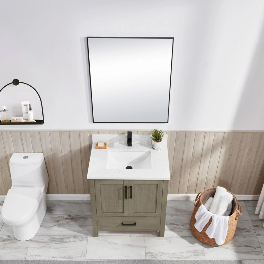 Bathroom vanity with wooden cabinets and white countertop, featuring a toilet and towel on the side.