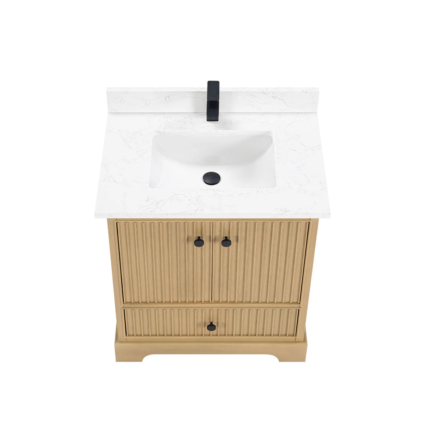 Bathroom vanity with wooden cabinet and white countertop in a bathroom setting.