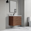 Bathroom with wooden vanity, sink, and mirror against a gray wall.