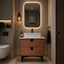 Bathroom with wooden vanity, white sink, and illuminated mirror.